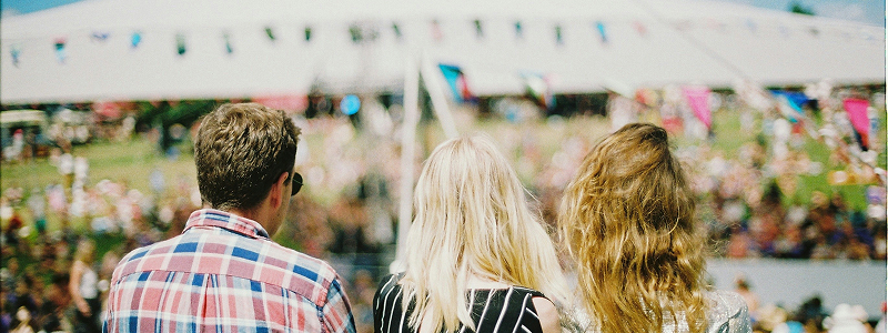 Crowd at outdoor festival with colorful flags